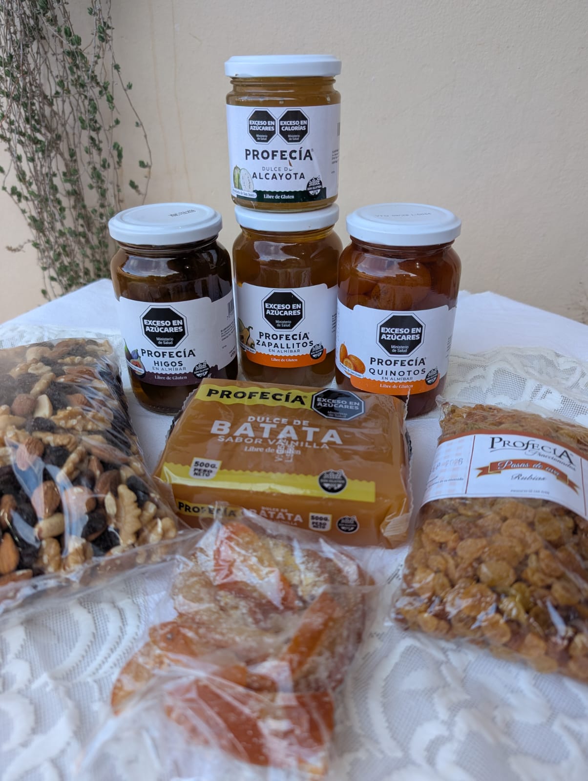 Frascos de dulces Profecía (higos, quinotos, zapallitos y alcayota), dulce de batata, pasas y frutos secos sobre una mesa